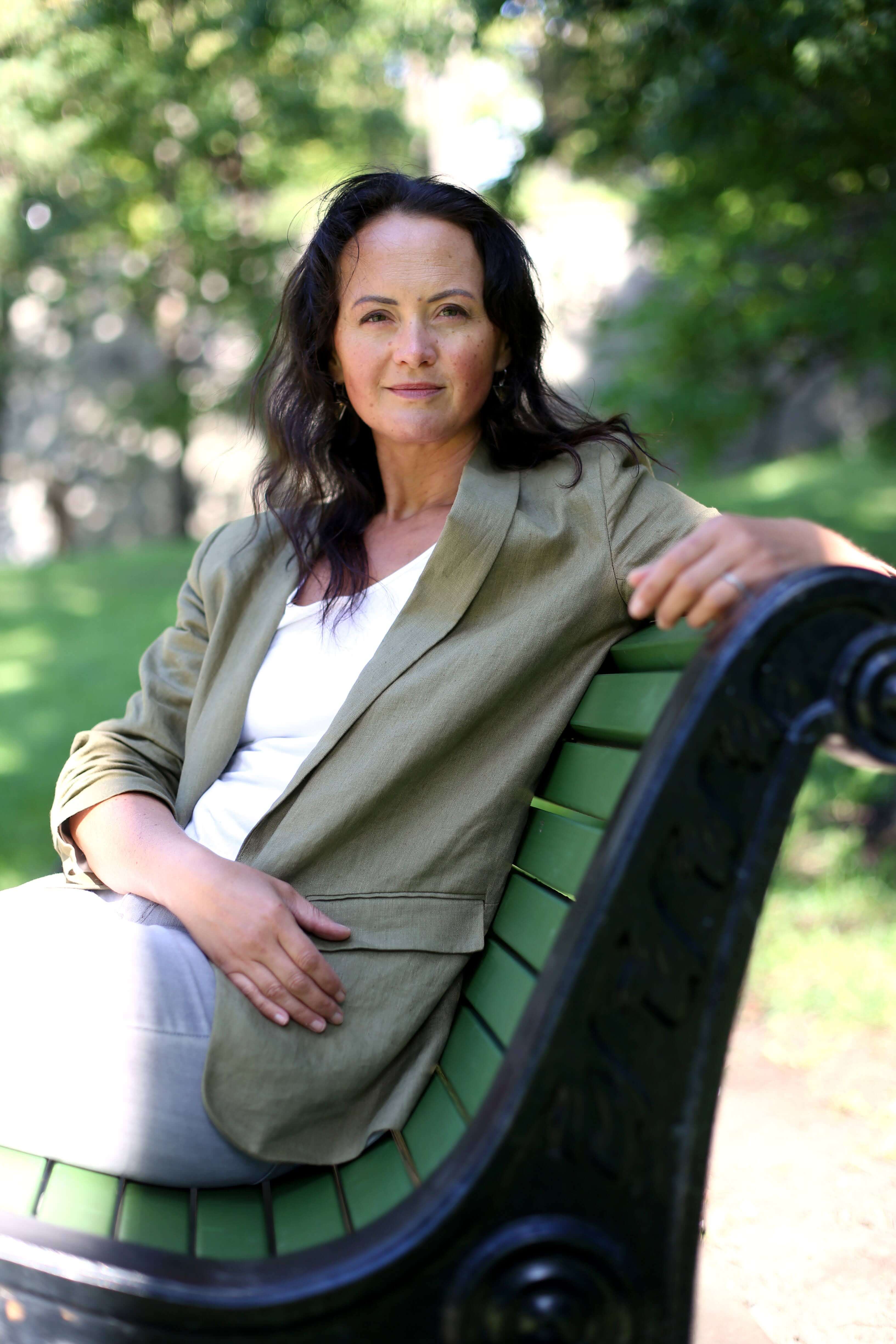 Tiina Urm, seated outdoors in a park in warm natural light